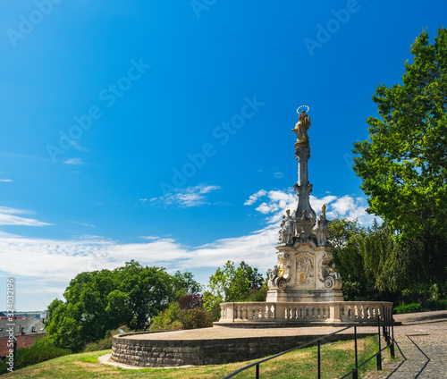 Nitra Castle in Old Town of Nitra, Slovakia. Panoramic summer view of Plague Column statue under blue sky with clouds, beautiful summer day
