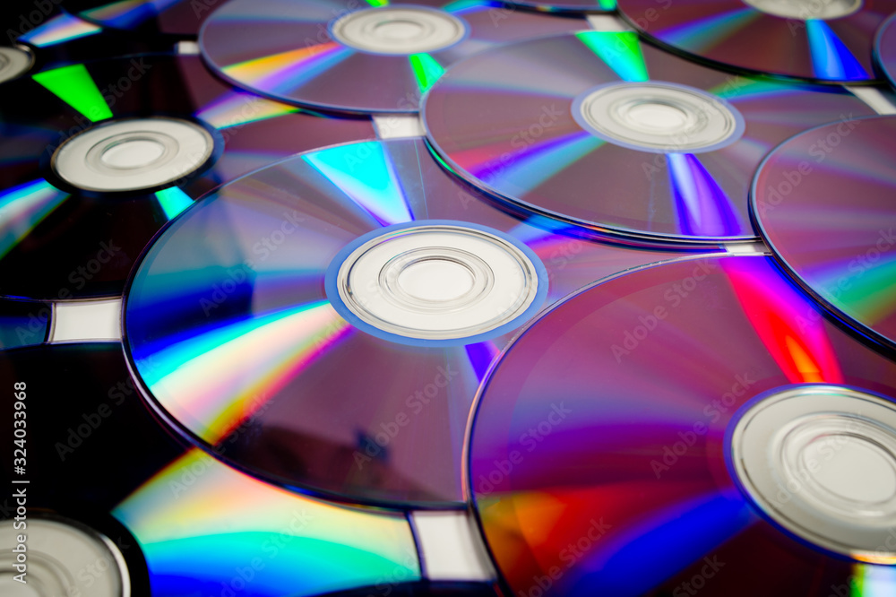 Background CD and DVD discs laid out on a flat surface. Background for saving information. Abstraction. Background CD and DVD discs laid out on a flat surface. Background for saving information. Abstraction.