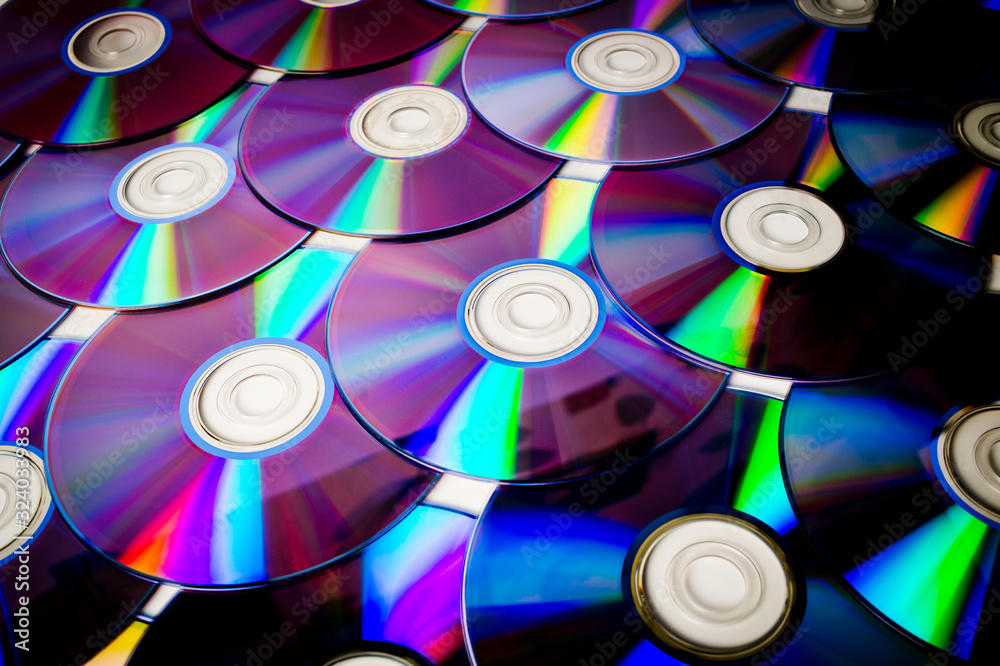 Background CD and DVD discs laid out on a flat surface. Background for saving information. Abstraction. Background CD and DVD discs laid out on a flat surface. Background for saving information. Abstraction.