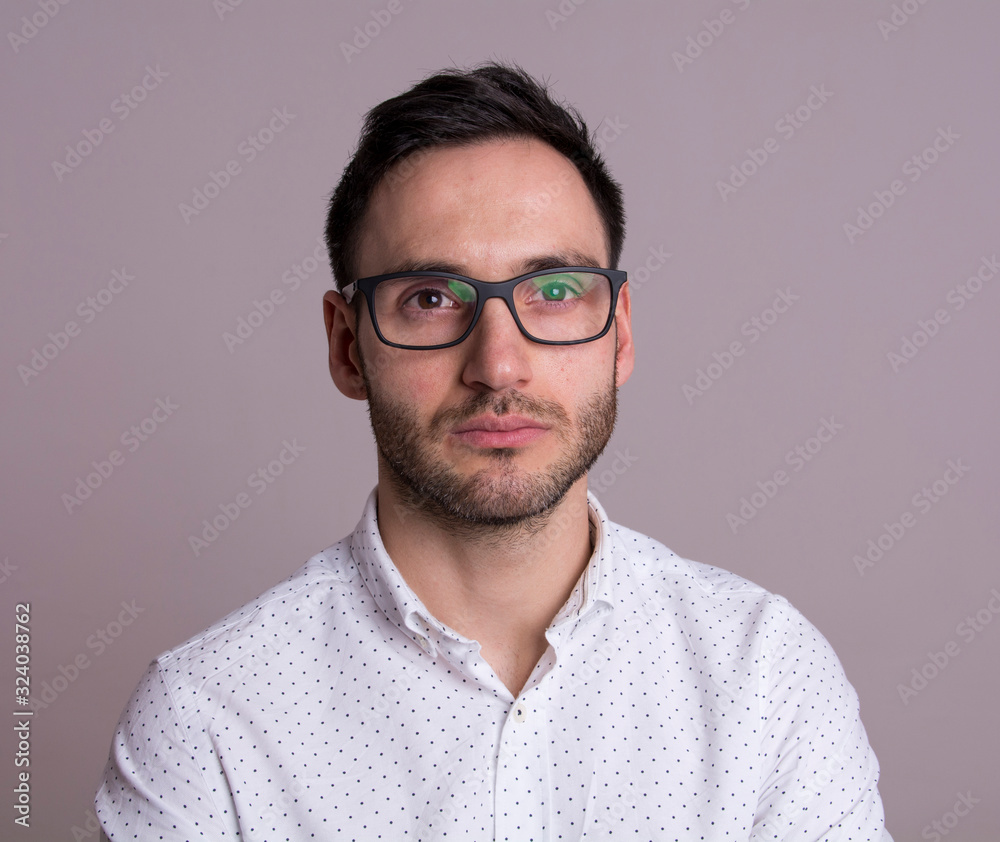 Portrait of a handsome young man with black glasses. Pensive pose. Portrait of a handsome young man with black glasses. Pensive pose.