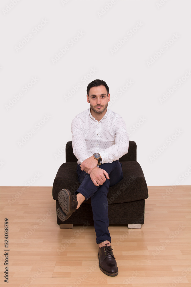 Handsome businessman sitting on couch with hands and legs crossed. Stylish attitude with dots shirt. Handsome businessman sitting on couch with hands and legs crossed. Stylish attitude with dots shirt.