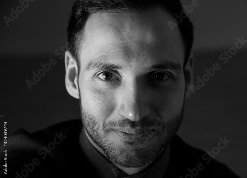 Portrait in black and white of a handsome man looking at camera. Stylish attitude.
