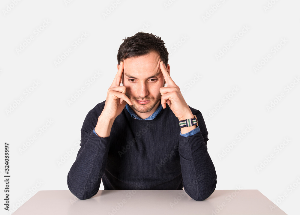 Young businessman meditating on the table. Man with headache Young businessman meditating on the table. Man with headache