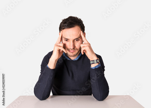 Young businessman meditating on the table. Man with headache
