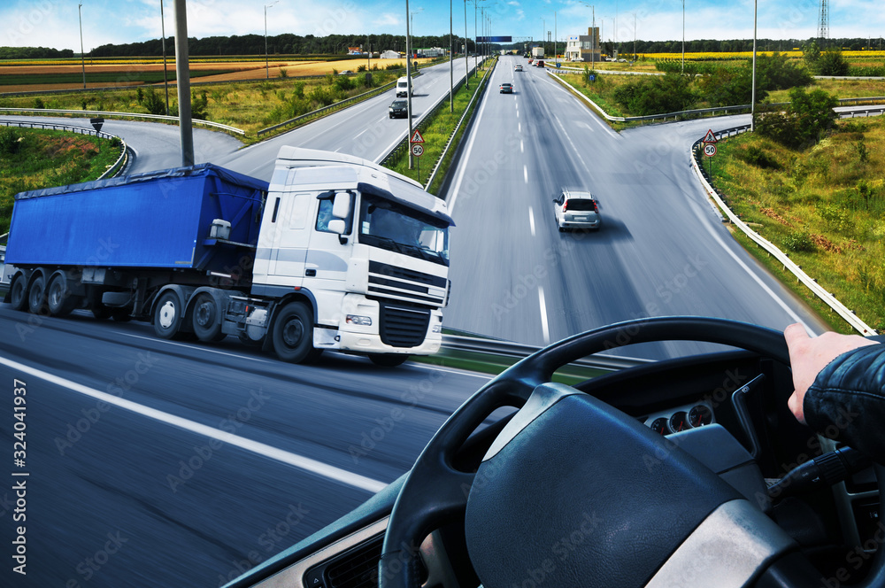 Abstract background with a truck, truck steering wheel and a road with cars and a sky