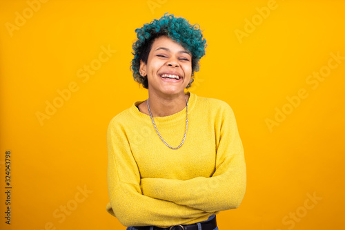 young girl or brunette woman with blue curls isolated on yellow background