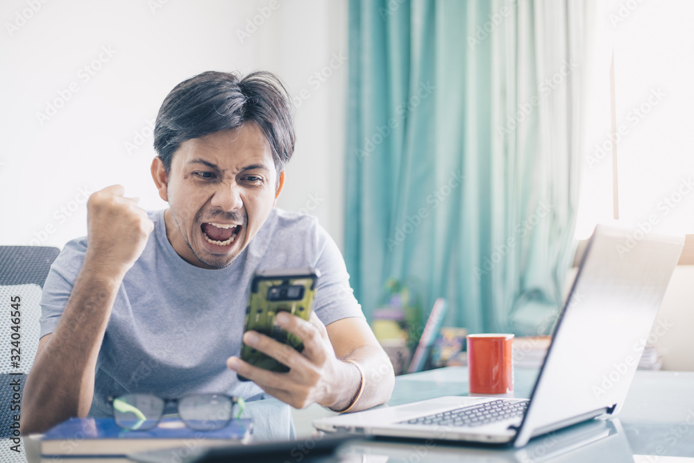 Good news,Young Asian office worker receiving great news over his smartphone Good news,Young Asian office worker receiving great news over his smartphone