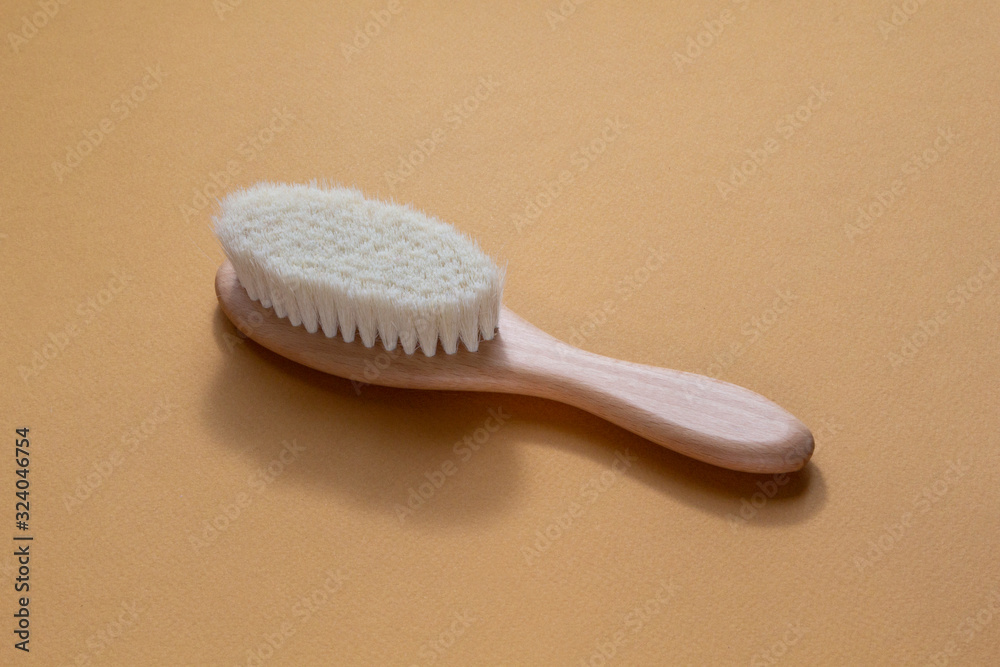 Wooden Hairbrush on a beige background. Baby Care concept. Wooden Hairbrush on a beige background. Baby Care concept.
