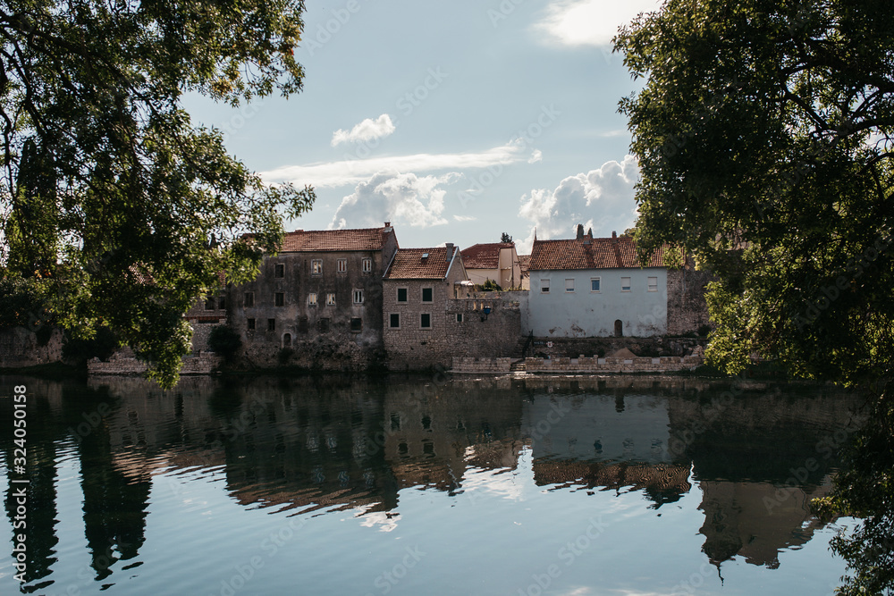 Obraz premium Picturesque landscape view of beautiful old city of Trebinje and Trebisnjica river, Bosnia and Herzegovina. Reflections of city on river. September, 2018.