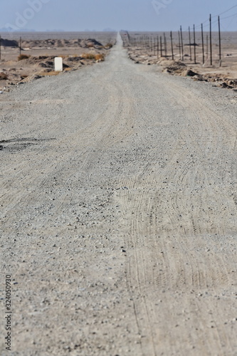 Dirt road straight to horizon-barren lands around Pochengzi site-Guazhou county-Gansu-China-0702