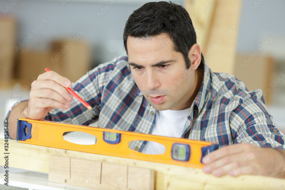 man with spirit level on wood man with spirit level on wood