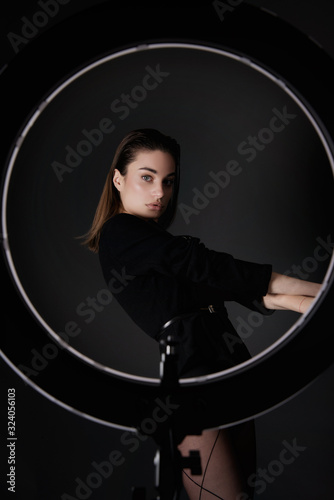 vogue fashion style female model posing in studio wearing trendy  simple elegant black outfit 