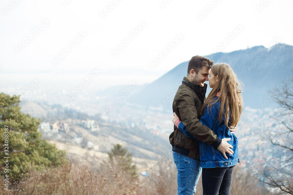 Happy young couple with a panoramic view in background. Love concept. Relationship happiness.