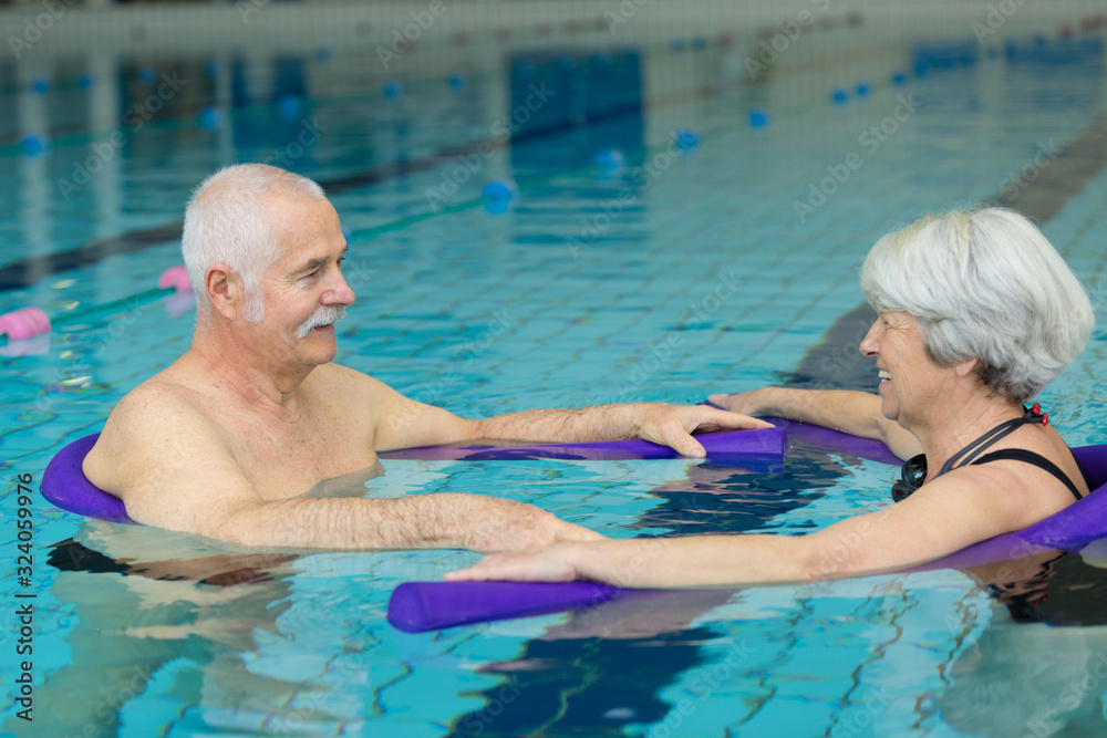 Fototapeta premium a senior couple is swimming slowly in the swimming pool