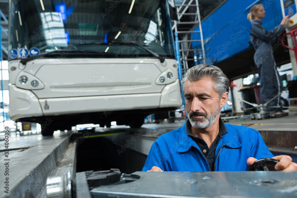 man working in bus garage man working in bus garage