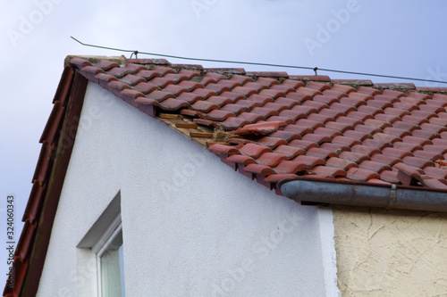 Dachschaden nach Sturm. Kaputte Dachziegel auf einem Haus Dach 