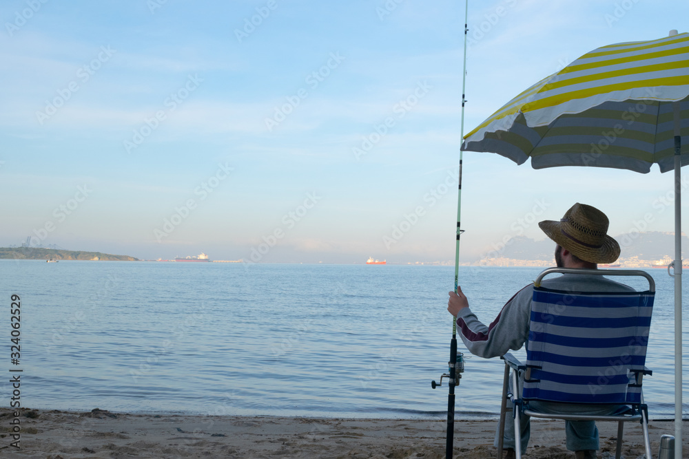 Man sitting fishing on the seashore