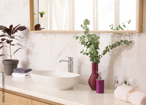 Stylish bathroom interior with countertop  mirror and plants. Design idea