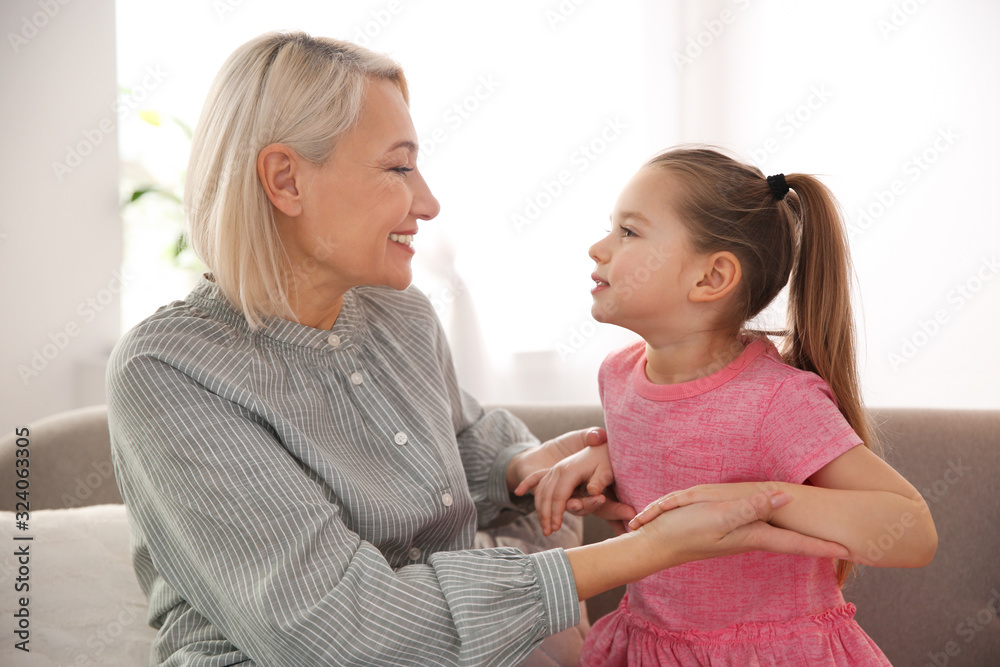 Mature woman with her little granddaughter at home - obrazy, fototapety, plakaty 