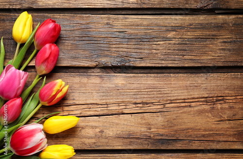 Beautiful spring tulips on wooden background  flat lay. Space for text