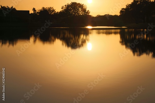 Sunset casting orange glow over lake