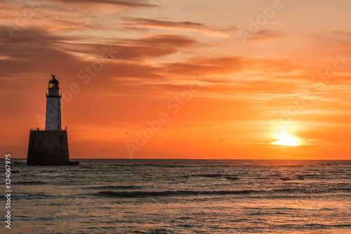 Lighthouse in the sea during sunrise