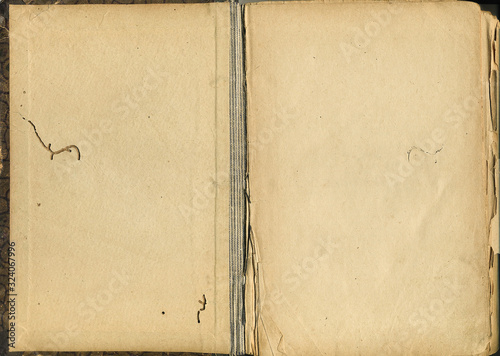 Antique book unfolded with aged textured paper inside. Old book opened to blank pages closeup. Vintage texture surface backdrop with empty place for text or design.
