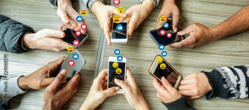 Group of millennial friends using mobile phones - Young people addiction to technology trends following and chatting with emoji on smartphones - Tech and millennial concept photo