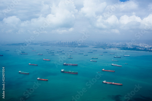 High angle view of barges and cargo ships in a bay, cityscape in the distance. photo