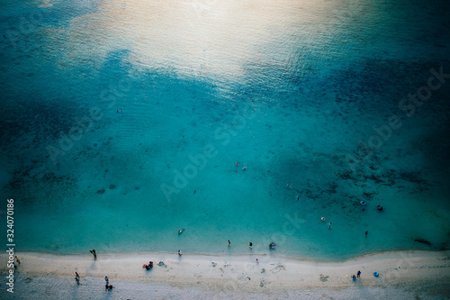 High angle view of crystal clear waters and white sandy beach.