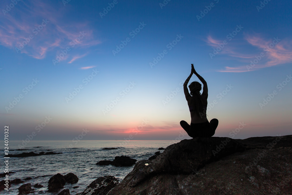 Φωτογραφία Silhouette of a yoga woman in Lotus position on the evening ocean