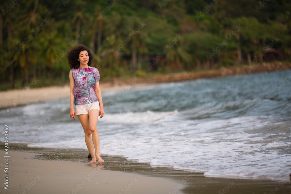 Young woman of mixed race in the waves on the sea beach. Young woman of mixed race in the waves on the sea beach.