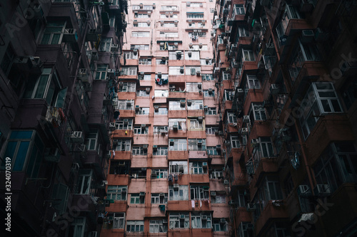 Low angle view of facade of towering residential complex with windows and balconies.,Hong Kong