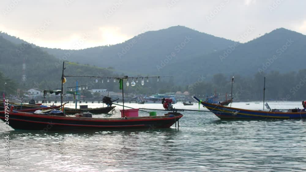 Fishing boat swaying gently on the waves in a cozy bay Fishing boat swaying gently on the waves in a cozy bay