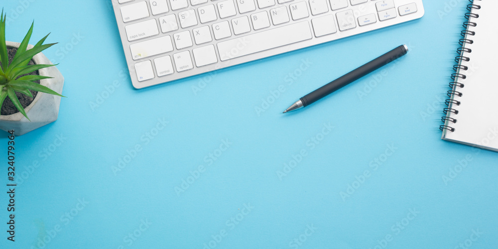 Blue desk office with laptop, smartphone and other work supplies with cup of coffee. Top view with copy space for input the text. Designer workspace on desk table essential elements on flat lay Blue desk office with laptop, smartphone and other work supplies with cup of coffee. Top view with copy space for input the text. Designer workspace on desk table essential elements on flat lay
