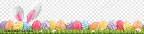 Foto Easter bunny ears with easter eggs on meadow with flowers background banner tran