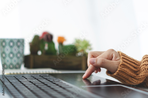 Woman hand using laptop or smartphone to work study on work desk with clean nature background background. Business, financial, trade stock maket and social network.