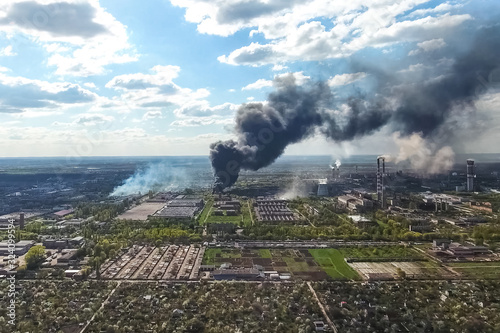 major fire at the factory. dark puffs of smoke from buildings.