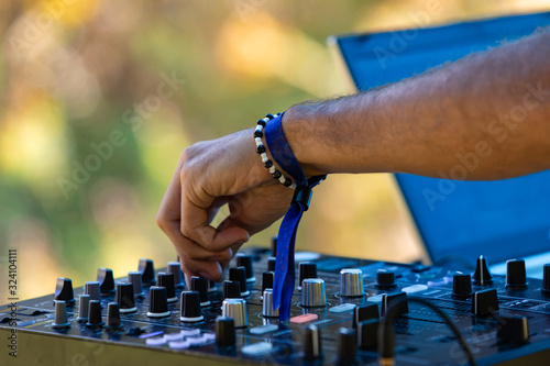 A close up selective focus view on the hands of a music DJ at work during a festival celebrating culture, acoustic sounds and alternative communities