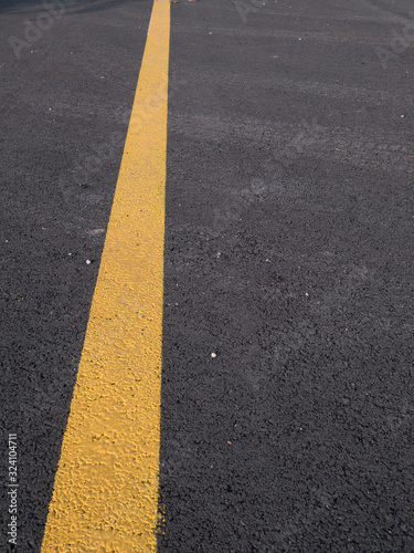 Yellow line across dark asphalt