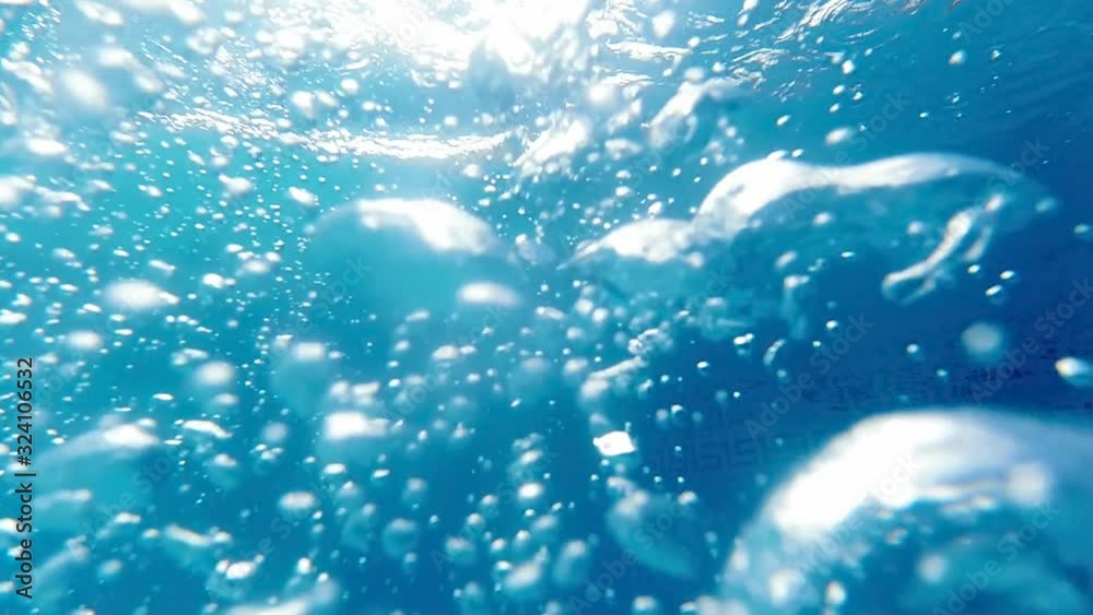 Slow motion underwater video of air bubbles rising and floating up in the swimming pool