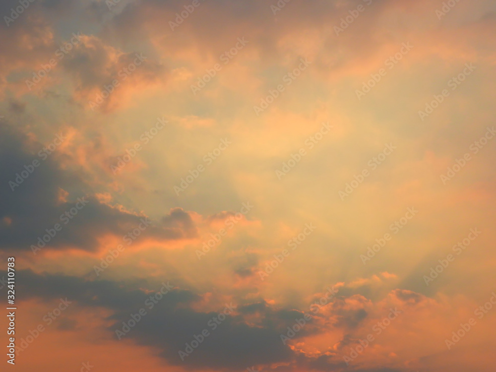 Beautiful sunset sky and dark clouds with dramatic light, Twilight sky background, Bright orange sky and light of the sun in center-Image