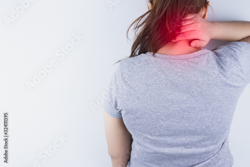 Closeup woman suffering from neck and shoulder pain with red spot. Health care and medical concept.