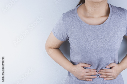 Closeup woman suffering from stomach pain. Health care and medical concept.