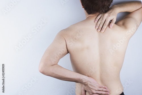 Closeup man suffering from lower back and neck pain. Health care and medical concept.