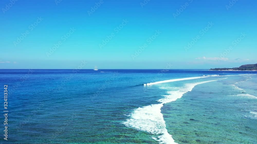 White waves of blue sea splashing over calm turquoise lagoon with coral reefs under clear bright sky, Malaysia White waves of blue sea splashing over calm turquoise lagoon with coral reefs under clear bright sky, Malaysia