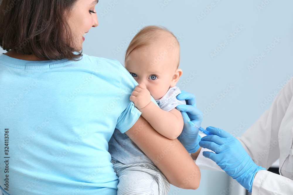 Pediatrician vaccinating little baby in clinic Pediatrician vaccinating little baby in clinic