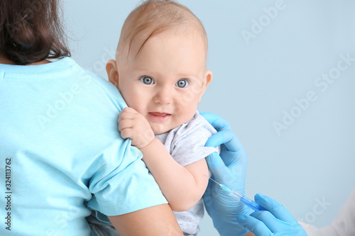 Pediatrician vaccinating li...