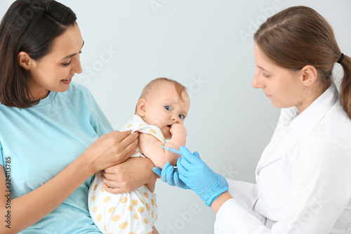 Pediatrician vaccinating li...