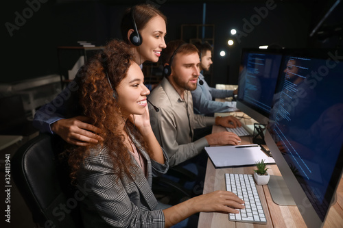 Technical support agents working in office at night